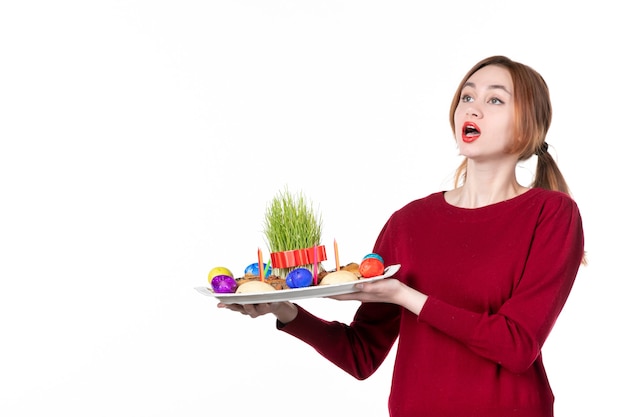 Vista frontal de la joven celebración honca con semeni y dulces novruz sobre fondo blanco concepto ejecutante vacaciones etnia colores primavera