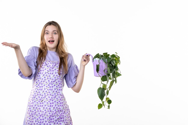 vista frontal joven mujer sosteniendo maceta con planta sobre fondo blanco hoja jardín flor hierba compras suelo planta mujer verde