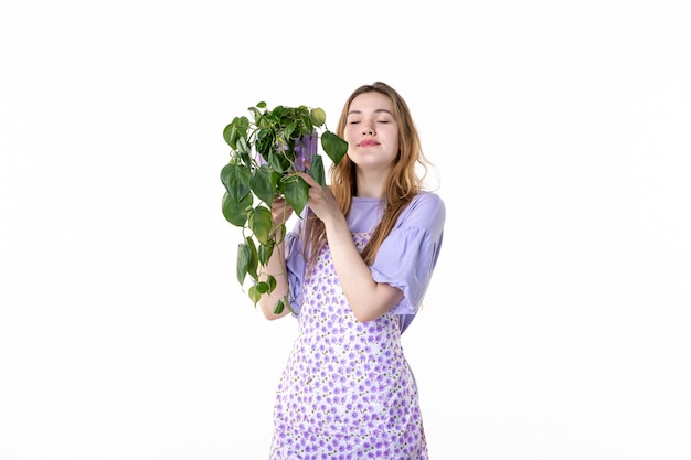 vista frontal joven mujer sosteniendo maceta con planta sobre fondo blanco hoja jardín flor hierba suelo planta mujer trabajo verde