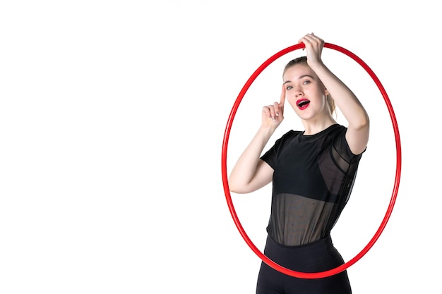 Vista frontal joven mujer sosteniendo rojo hula hoop para deporte sobre fondo blanco atleta color deporte mujer salud cuerpo