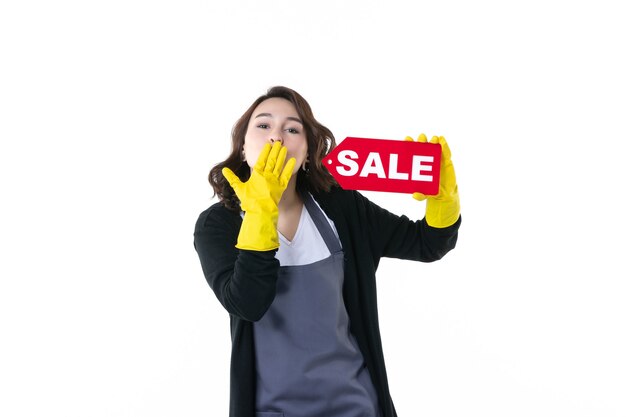 Foto vista frontal joven mujer sosteniendo rojo venta escrito sobre fondo blanco jardín flor hoja trabajo césped jardinero compras