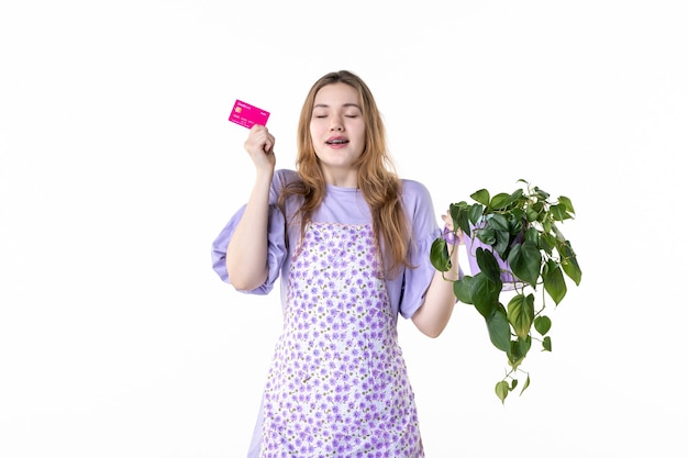 Vista frontal joven mujer sosteniendo tarjeta bancaria y flor sobre fondo blanco color de la flor jardinero de jardín planta hierba arbusto mujer dinero