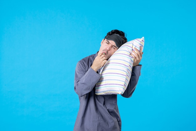 Vista frontal joven en pijama cepillándose los dientes y tratando de dormir sobre fondo azul pesadilla color descanso humano despertar limpio sueño cama noches