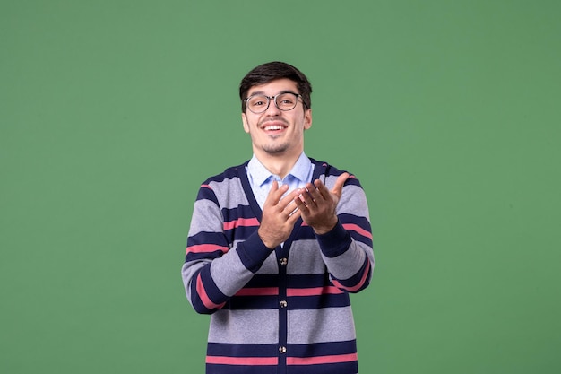 Vista frontal joven profesor sonriendo sobre fondo verde trabajador biblioteca de color lección de trabajo escuela mujer estudiante universitario libro