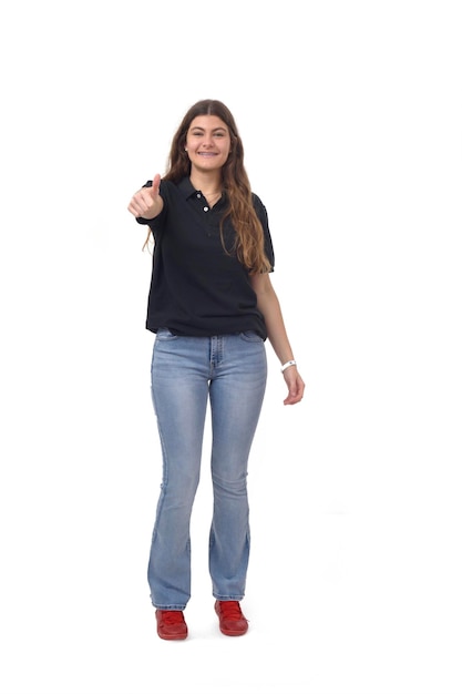 Foto vista frontal de la joven que muestra los pulgares hacia arriba sonriendo y mirando a la cámara sobre fondo blanco.