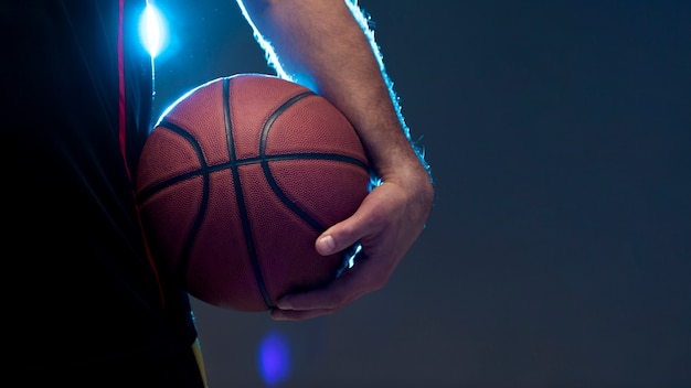 Foto vista frontal del jugador de baloncesto sosteniendo la pelota con espacio de copia