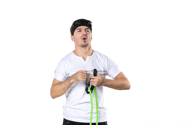 Vista frontal macho joven con expansor sobre fondo blanco en forma de atleta gimnasio dieta régimen deportivo estilo de vida corporal