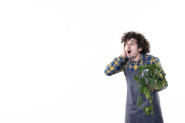 Vista frontal macho joven con planta verde en maceta sobre fondo blanco árbol planta suelo flor emoción campo uniforme trabajo verde