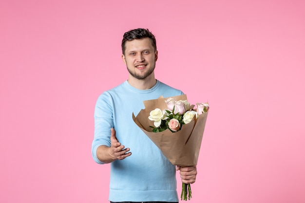 vista frontal, macho joven, con, ramo, de, hermoso, flores, en, rosa, plano de fondo, divertido, parque, sensual, día de la mujer, marcha, femenino, matrimonio, igualdad, amor