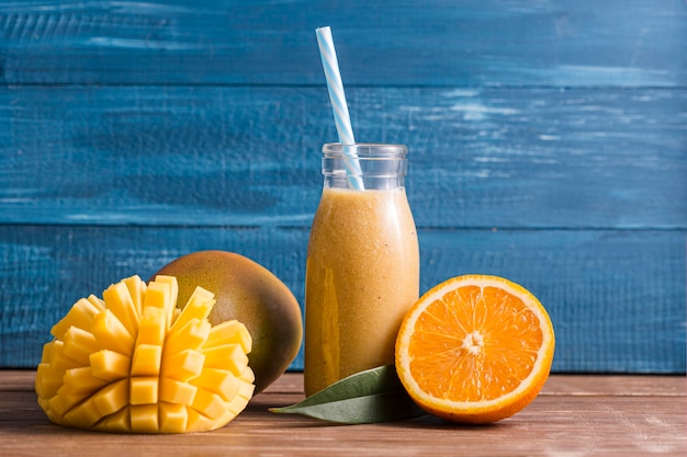 Vista frontal manga e laranja batido na garrafa