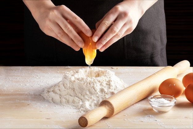 Foto vista frontal de las manos de mujer haciendo receta con rodillo de madera