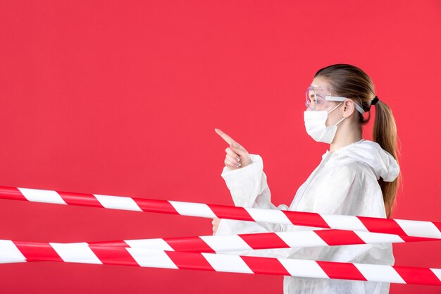 Foto vista frontal médica em traje de proteção e máscara em fundo vermelho hospital tecido covid- máscara vírus emoção saúde enfermeira cura