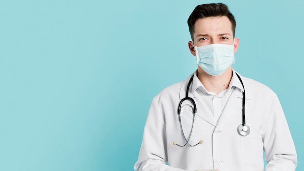 Foto vista frontal del médico con estetoscopio y máscara médica