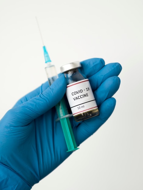 Foto vista frontal del médico con la vacuna de coronavirus con jeringa