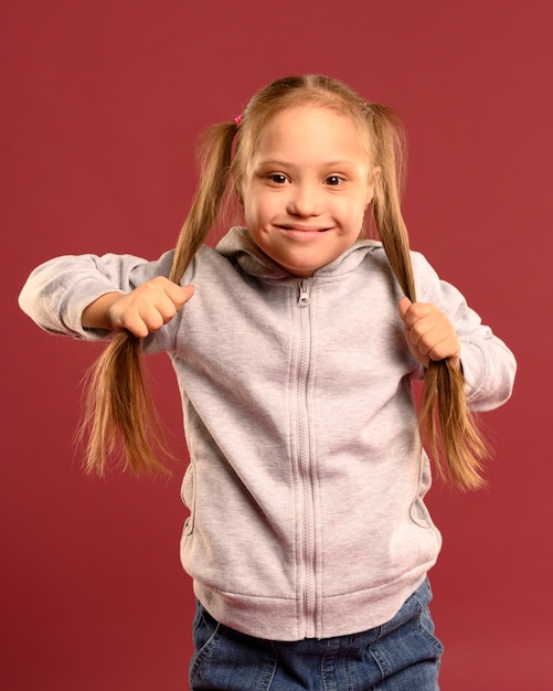 Foto vista frontal menina segurando o cabelo dela