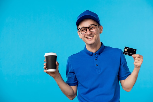 Vista frontal del mensajero masculino con café y tarjeta bancaria en azul