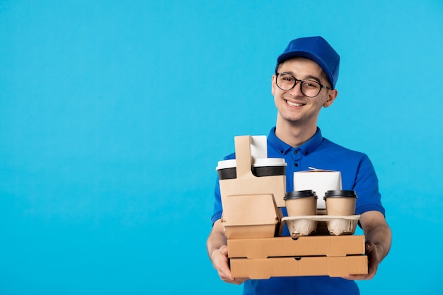 Vista frontal del mensajero masculino en uniforme azul con café en azul