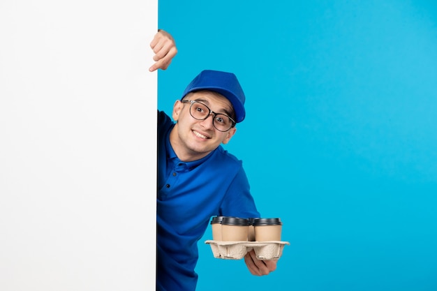 Vista frontal del mensajero masculino en uniforme azul con café en azul