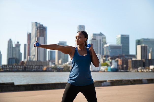 Foto vista frontal mujer embarazada haciendo deporte al aire libre