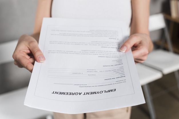 Foto vista frontal de la mujer entregándole un contrato