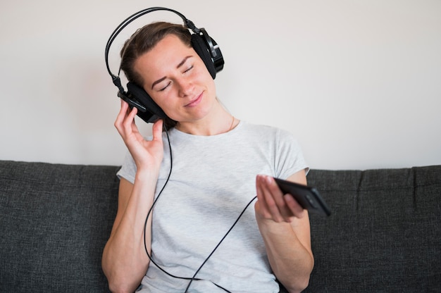 Foto vista frontal de la mujer escuchando música