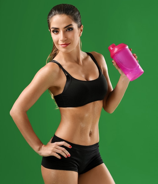 Vista frontal de la mujer en forma con una botella de agua deportiva.