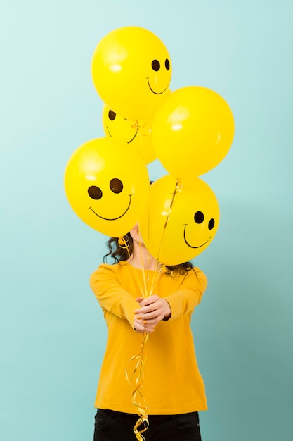 Foto vista frontal de mujer con globos