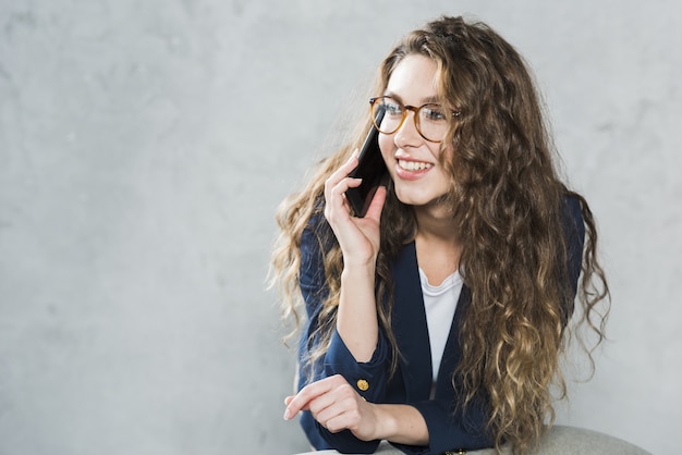 Foto vista frontal de la mujer hablando por teléfono mientras espera su entrevista de trabajo