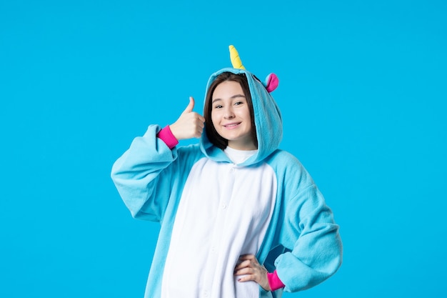 Vista frontal mujer joven en fiesta de pijamas sobre fondo azul amigos pesadilla dormir cama sueño descansar color tarde en la noche