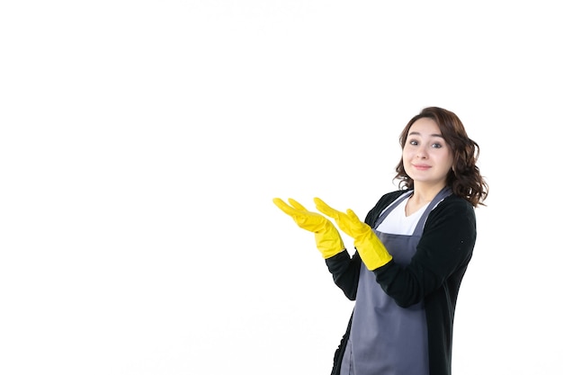 Vista frontal mujer joven en guantes amarillos sobre fondo blanco jardín árbol suelo naturaleza flor jardinero limpieza colores