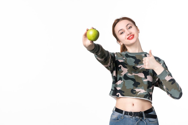 Vista frontal mujer joven con manzana verde sobre blanco