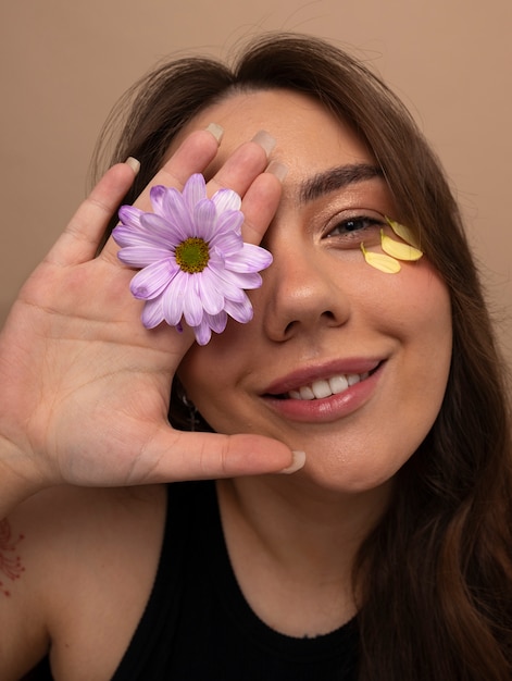 Foto vista frontal mujer joven posando con flor