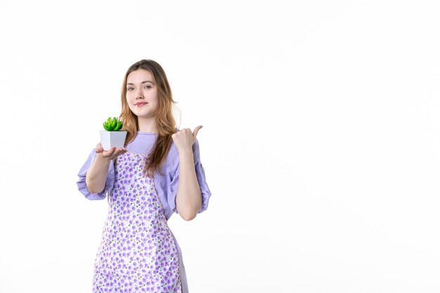 vista frontal mujer joven sosteniendo pequeña planta verde sobre fondo blanco hoja planta trabajo verde planta de interior mujer flor césped jardín