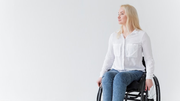 Vista frontal de la mujer en silla de ruedas con espacio de copia