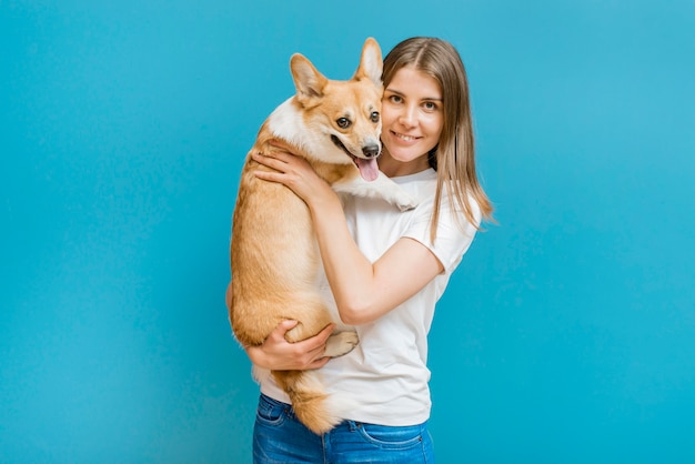 Vista frontal de la mujer sonriente posando con su perro