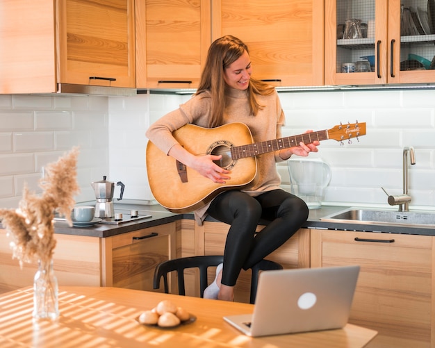 Foto vista frontal de la mujer tocando la guitarra