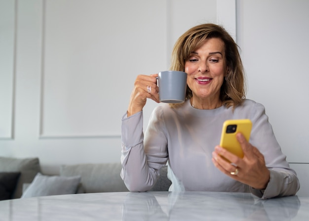 Foto vista frontal mujer tomando un descanso con teléfono inteligente