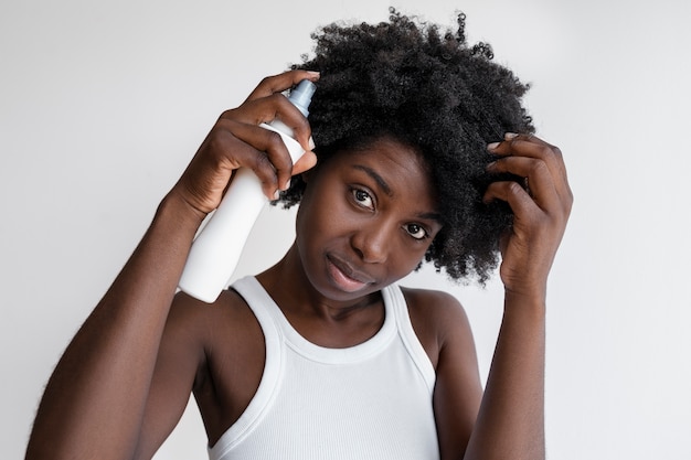 Foto vista frontal mujer usando producto para el cabello