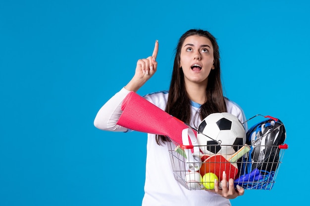 Foto vista frontal de las mujeres jóvenes después de las compras deportivas en la pared azul