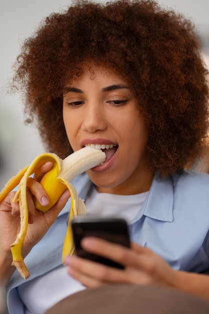 Foto vista frontal mulher comendo banana