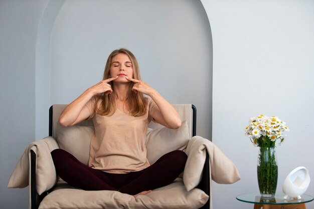 Foto vista frontal mulher praticando ioga facial