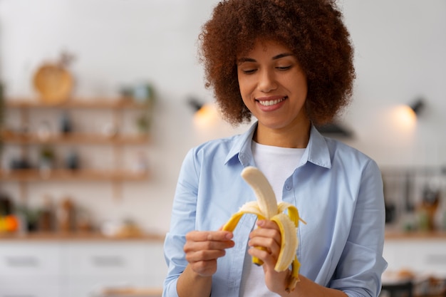 Foto vista frontal mulher segurando banana