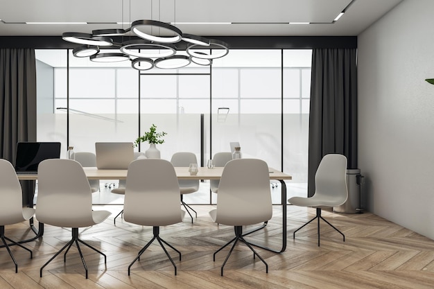 Vista frontal na mesa de reunião de madeira clara moderna com laptops cercados por cadeiras elegantes na sala de conferências com lustre de círculo no piso em parquet superior e porta de vidro renderização em 3D