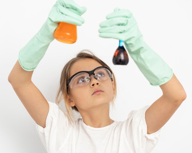 Vista frontal de la niña haciendo experimentos de química con tubos de ensayo