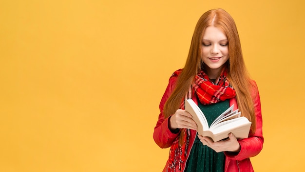 Vista frontal niña leyendo libro