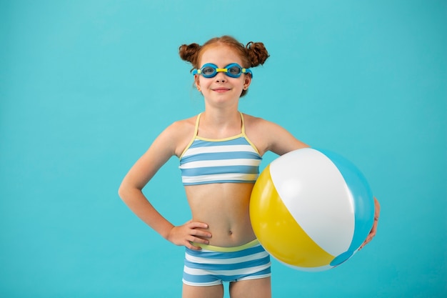 Foto vista frontal niña sonriente sosteniendo pelota