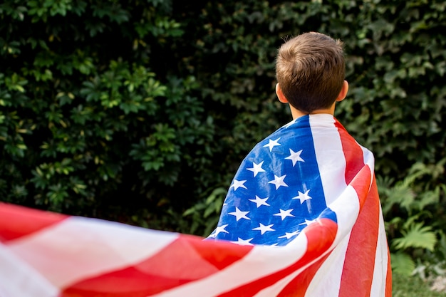 Foto vista frontal niño con bandera de estados unidos