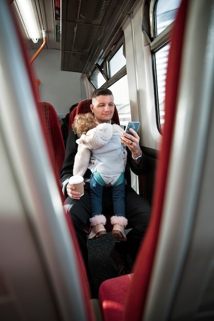 Foto vista frontal padre con bebé en transporte público