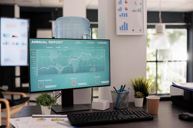 Vista frontal de la pantalla de la computadora con el informe anual de la empresa y el gráfico de crecimiento anual. No hay personas en una oficina comercial con un monitor que muestre un software de curva de aumento.