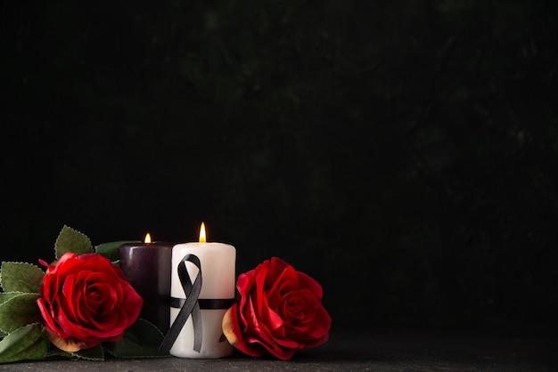 Vista frontal del par de velas flores rojas sobre negro